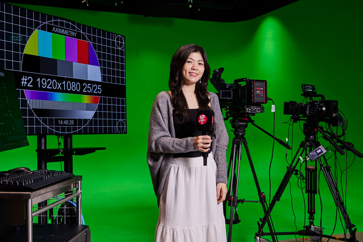 Lianhe Zaobao journalist Wun Yun Fang stands in front of television equipment doing a live broadcast