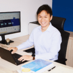 IRAS director Leong Shi Wei sitting at his desk with a laptop and computer.