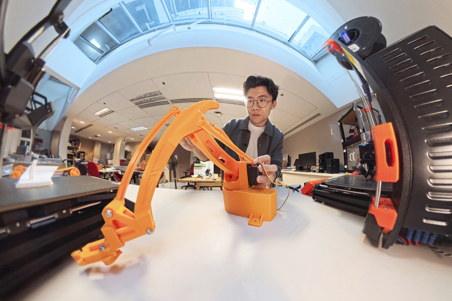 Xu Jialu NTU Renaissance Engineering Programme student using a 3-D printer