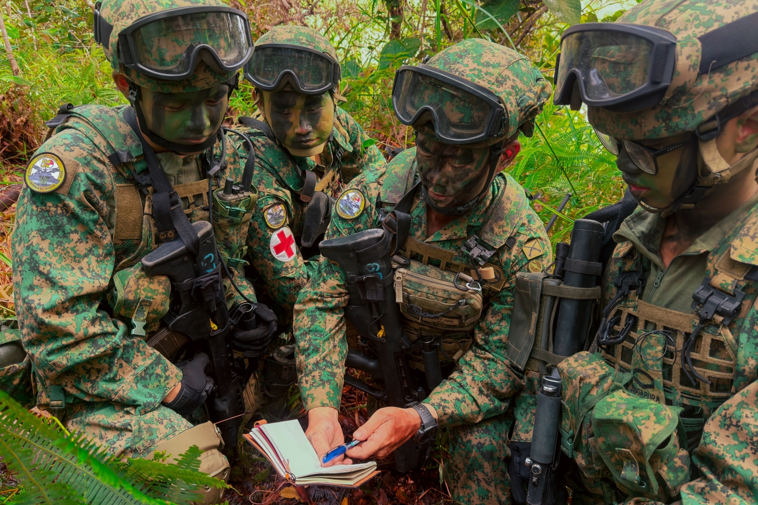 commanding officer of 1st battalion of singapore infantry regiment lieutenant-colonel scott ang (second from right) with his soldiers during a field operation, singapore armed forces scholarship recipient