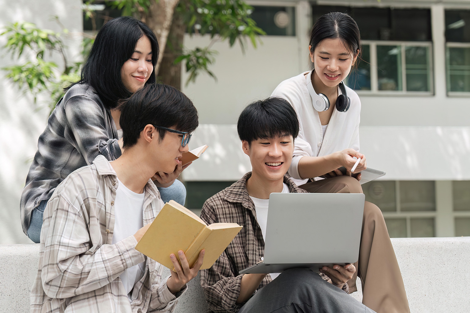 students discussing a project together using a laptop
