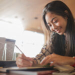 young female student taking notes